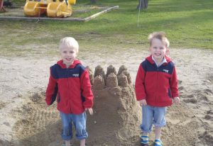 kids that are very proud of their sand castles